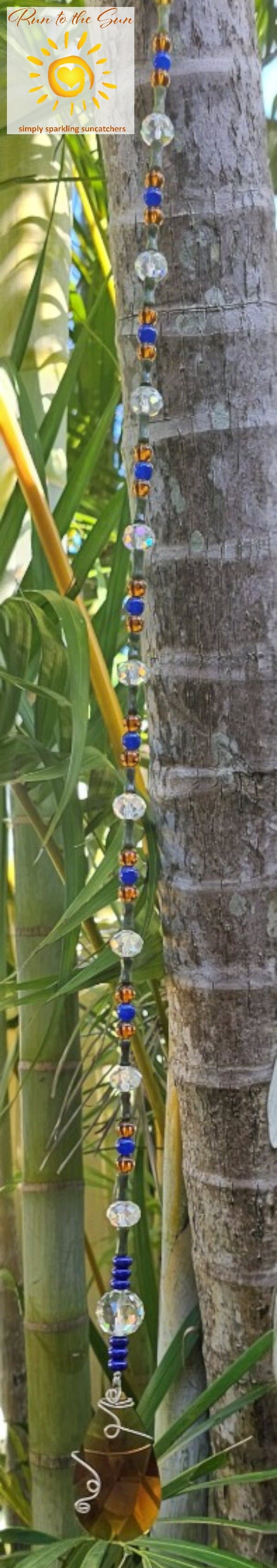 Amber wire-wrapped pendant with blue and amber glass beads with faceted glass highlights hanging view